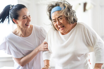 Young Asian nurse helping senior woman to walk around the nursing home. Elderly peoples and retirement home service concept.