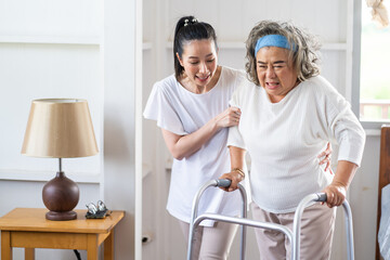 Young Asian nurse helping senior woman to walk around the nursing home. Elderly peoples and retirement home service concept.