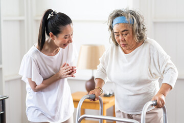 Fototapeta premium Young Asian nurse helping senior woman to walk around the nursing home. Elderly peoples and retirement home service concept.