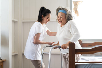 Young Asian nurse helping senior woman to walk around the nursing home. Elderly peoples and retirement home service concept.