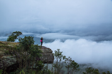 hiker on top mountain with clouds