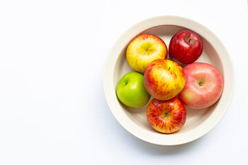 Ripe apples in bowl on white background. T