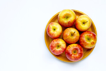Ripe apples on yellow plate on white background.