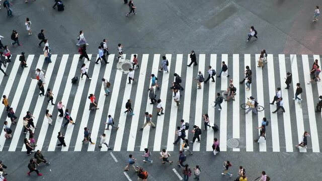 Aerial view of pedestrians walk at Shibuya Crossing. The scramble crosswalk is one of the largest in the world.