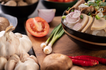 Scallions, peppers, garlic, and shiitake mushrooms on a wooden plate