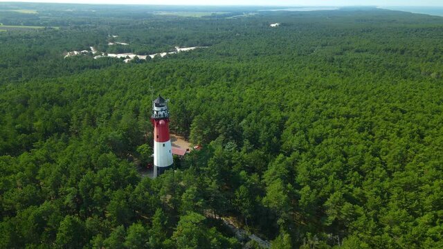 Stunning View Of Lighthouse Stilo Surrounded By A Dense Foliage Forest Landscape In Sasino, Poland During Daytime. - Aerial Shot
