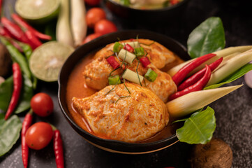Chicken curry in a bowl with lemongrass, kaffir lime leaves, tomatoes, lemon, and garlic