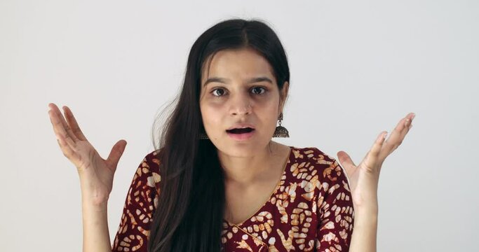 Indian woman completely pleasantly surprised taken aback in awesome disbelief good news of success victory win raises both her hands in the air on top and stares down the camera still in denial smiles