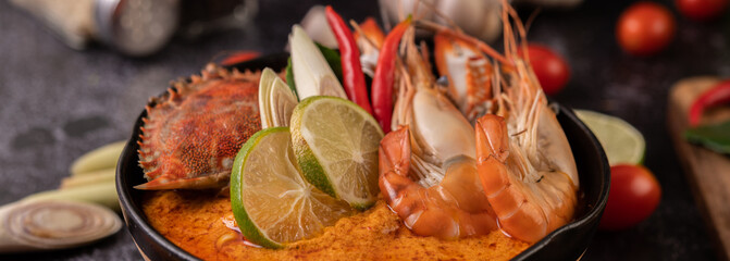 Tom yum with shrimp and crab with lime, chili, tomato, garlic, lemongrass and kaffir lime leaves.