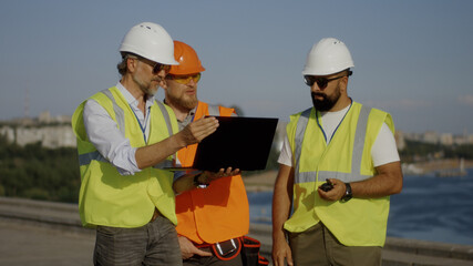 Builders using laptop on construction site