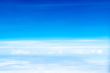 Beautiful nature blue sky with space above over bright white clouds view from window airplane