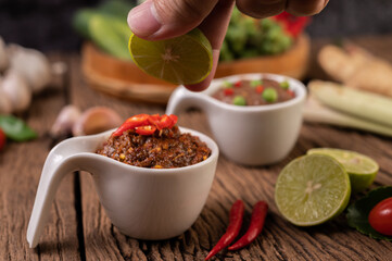 Red Eye Chili Paste with Lemon and Chili on Wooden Floor
