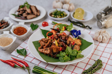 Pork Nam Tok with fried chili, tomato, lime, cucumber, and fresh pepper.