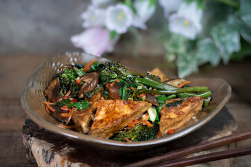 Asian cuisine: spicy fried tofu with broccolini and shiitake mushrooms (vegetarian, vegan)