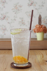 Lemon water with fresh lemons and green plants