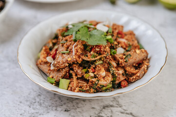 Pork liver salad with chili, roasted rice, spring onion, carrot, and cucumber.