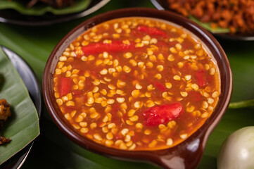 Chili sauce and ingredients placed on banana leaves.