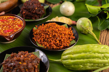 Crispy pork chili paste on banana leaves in a plate with side dishes.