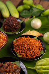 Crispy pork chili paste on banana leaves in a plate with side dishes.