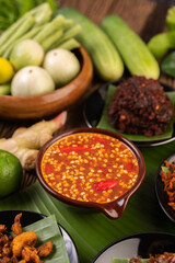 Chili sauce and ingredients placed on banana leaves.