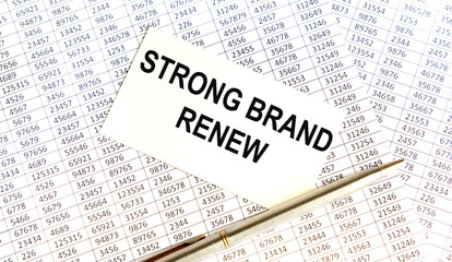 Obraz premium On the card is the inscription STRONG BRAND RENEW, next to the pen. The background is a report.