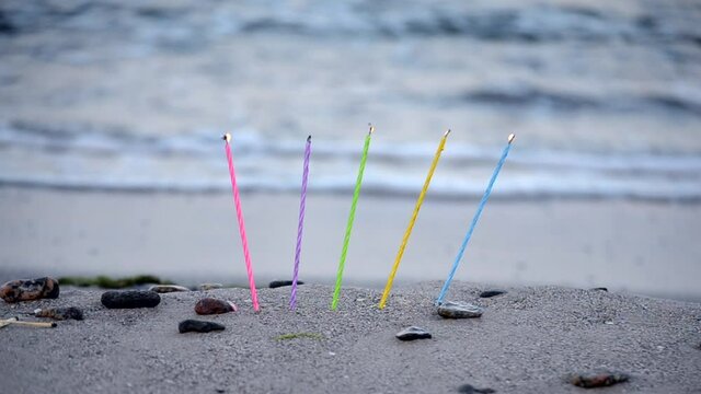 Candles inserted into the sand on a sandy beach on the sea ocean shore