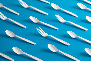 Disposable plastic cutlery forks and spoons with Blue background