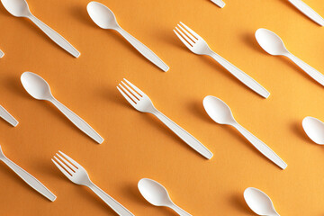 Disposable plastic cutlery forks and spoons forbidden with orange background