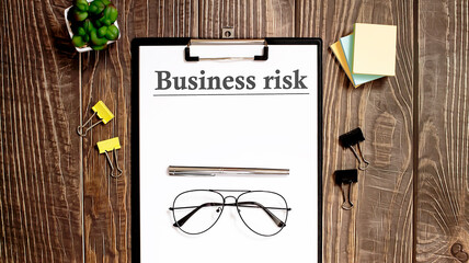 BUSINESS RISK form on a wooden table.