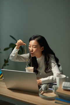 Hungry Student Eating Noodle While Learning At Home