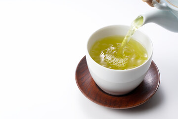 Pouring green tea into a teacup. Japanese green tea image