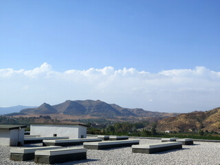 White clouds and low hills viewed over flat roof