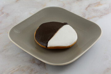 Black and white frosted round cookie on snack plate on table
