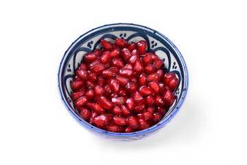 Pomegranate in white and blue ornaments bowl on white background