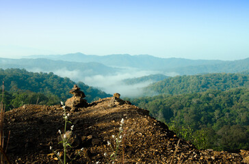 The small stones are stacked on top of the mountain, with complex mountains and beautiful white mist in the morning.