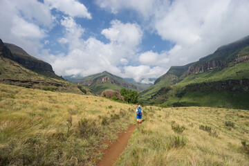 Fototapeta na wymiar Hiker heads into the rugged Drakensberg mountains
