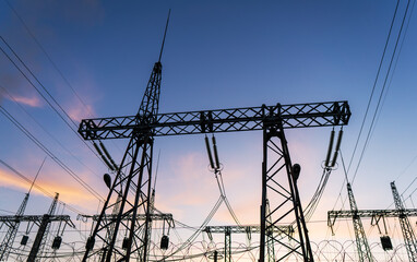 High-voltage power lines at sunset or sunrise. High voltage electric transmission tower