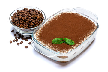 Traditional Italian Tiramisu dessert in glass baking dish and coffee beans isolated on white