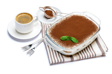 Traditional Italian Tiramisu dessert in glass baking dish and cup of fresh espresso coffee isolated on white background with clipping path