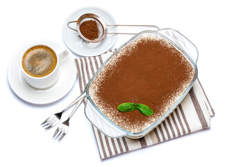 Traditional Italian Tiramisu dessert in glass baking dish and cup of fresh espresso coffee isolated on white background with clipping path