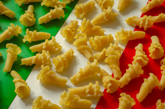 Dry gigli pasta on a green-white-red background.