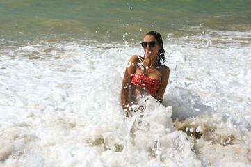 Fototapeta premium Young woman on sand by sea wave