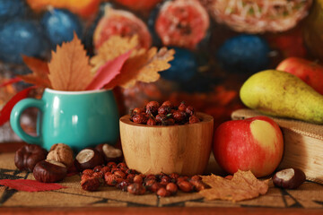 autumn composition on the table with rose hips and leaves