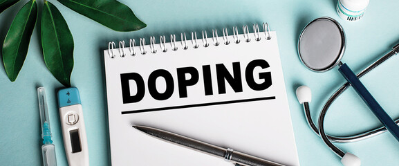 In a white notebook on a blue background, near a sheet of shefflers, a stethoscope, a syringe and...