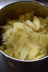 Thin sliced ginger in a pan. Cooking homemade ginger syrup.