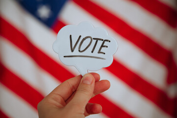 Vote word with American flag in the background. Election concept.