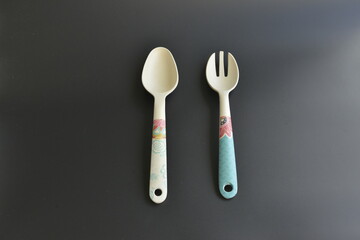 Kitchen utensils isolated on black background. Spoon and fork