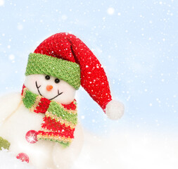 Snowman toy on the bokeh winter background . Christmas background. Copy space for text