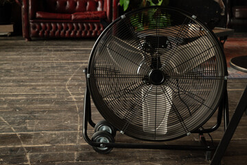 Round cooling fan on the wooden floor in room