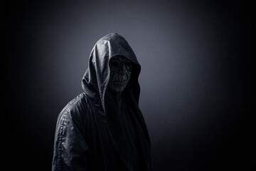 Ghostly figure in hooded cloak in the dark - obrazy, fototapety, plakaty